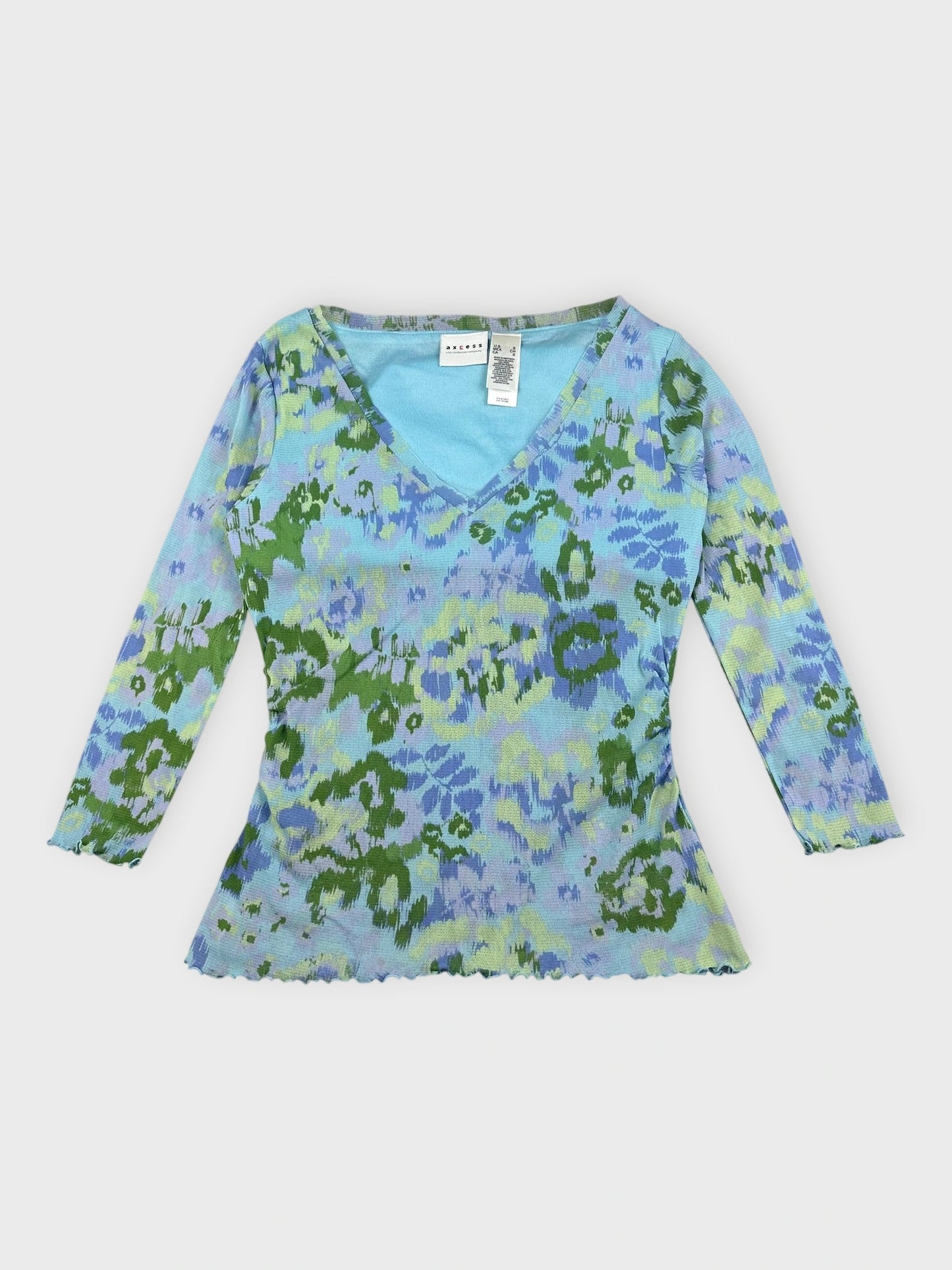 Front view of a printed v-neck top in blue and green floral pattern.