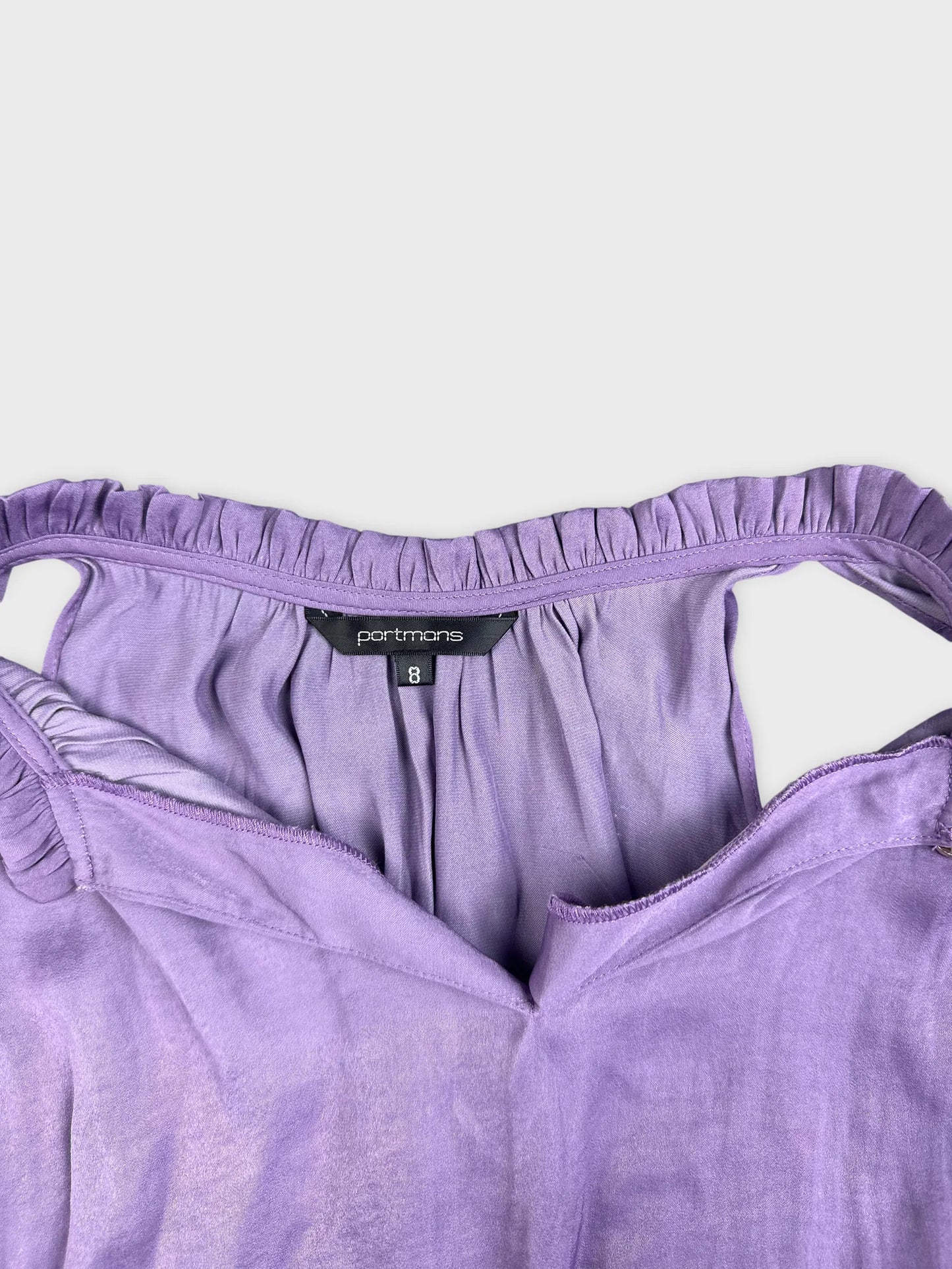 Detail view of purple balloon top featuring ruffled neckline.
