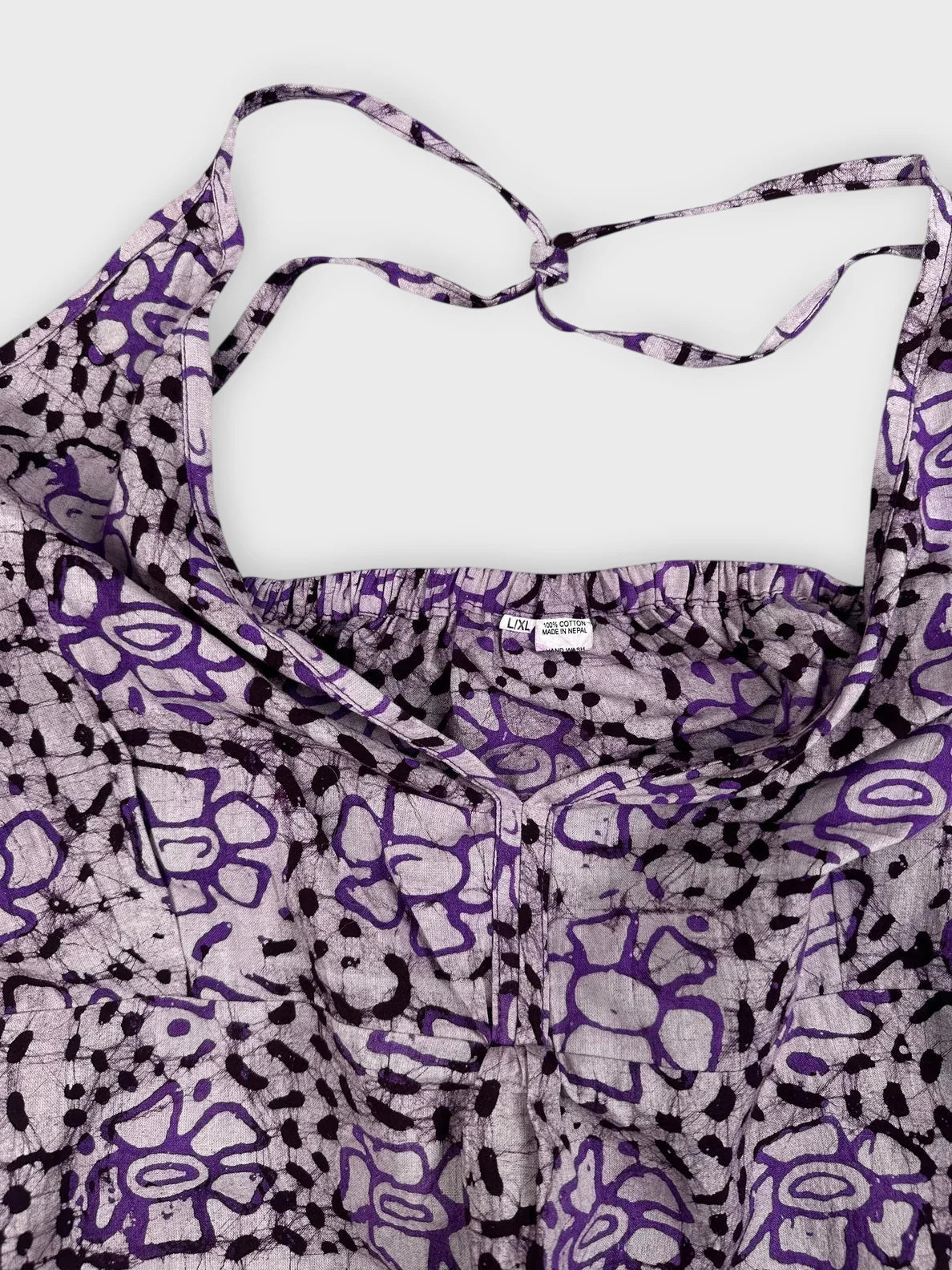 Purple floral halter top with tie detail view featuring a floral print.