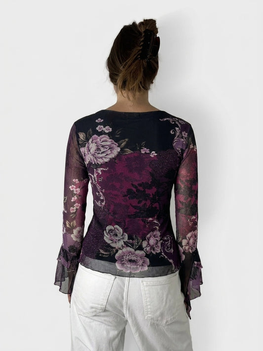 Back view of a purple floral lace top with bell sleeves.
