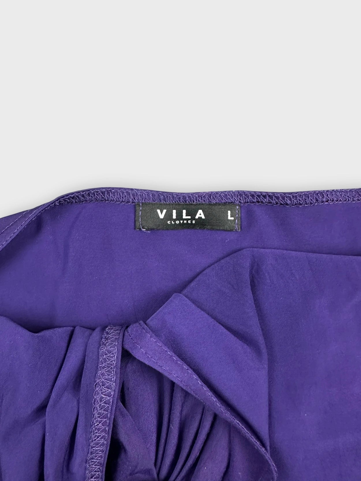 Detail view of purple halter top featuring unique ring detail.