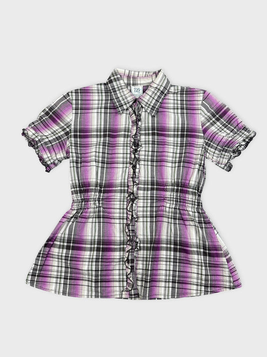 Front view of a purple plaid button-up peplum shirt with ruffled trim.