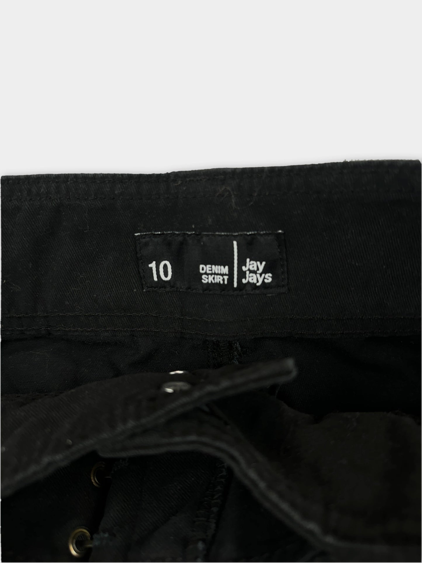 Detail view of a black denim mini skirt with an adjustable belt.