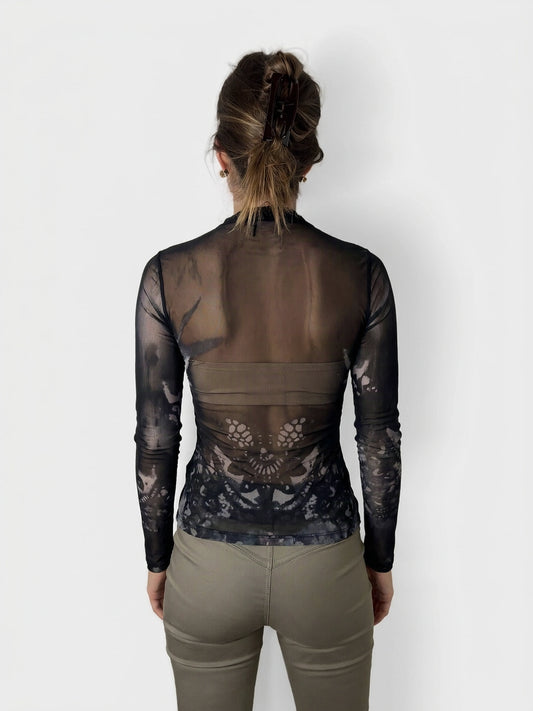 Back view of a sheer black long sleeve body shirt featuring a floral lace pattern.