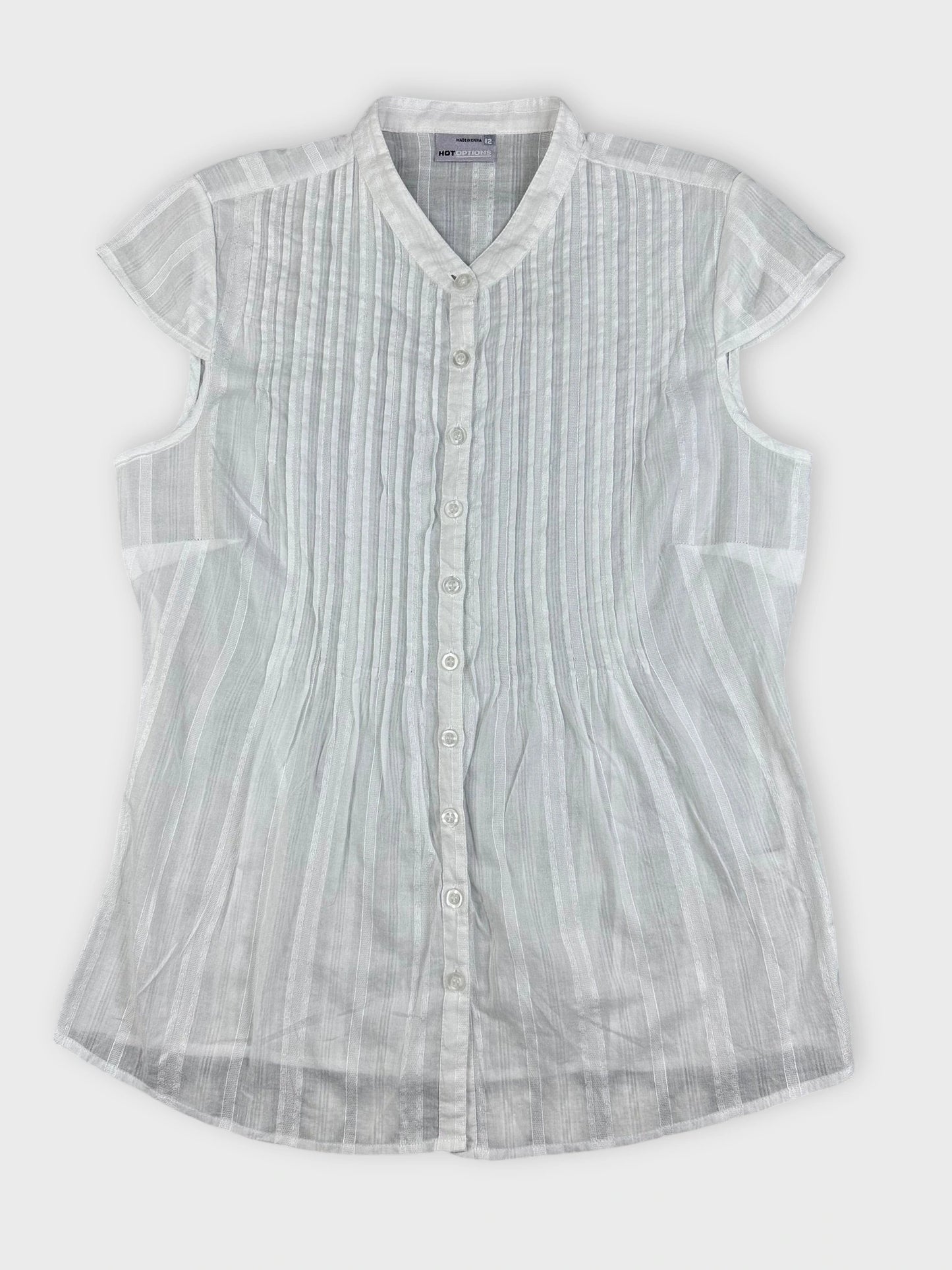 Sheer white blouse with pintuck detailing in a detail view.