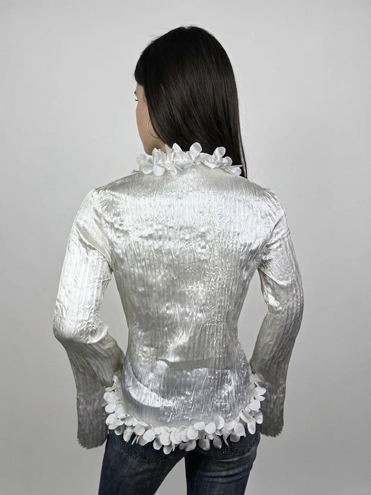 Back view of shiny white long sleeve blouse with floral trim.