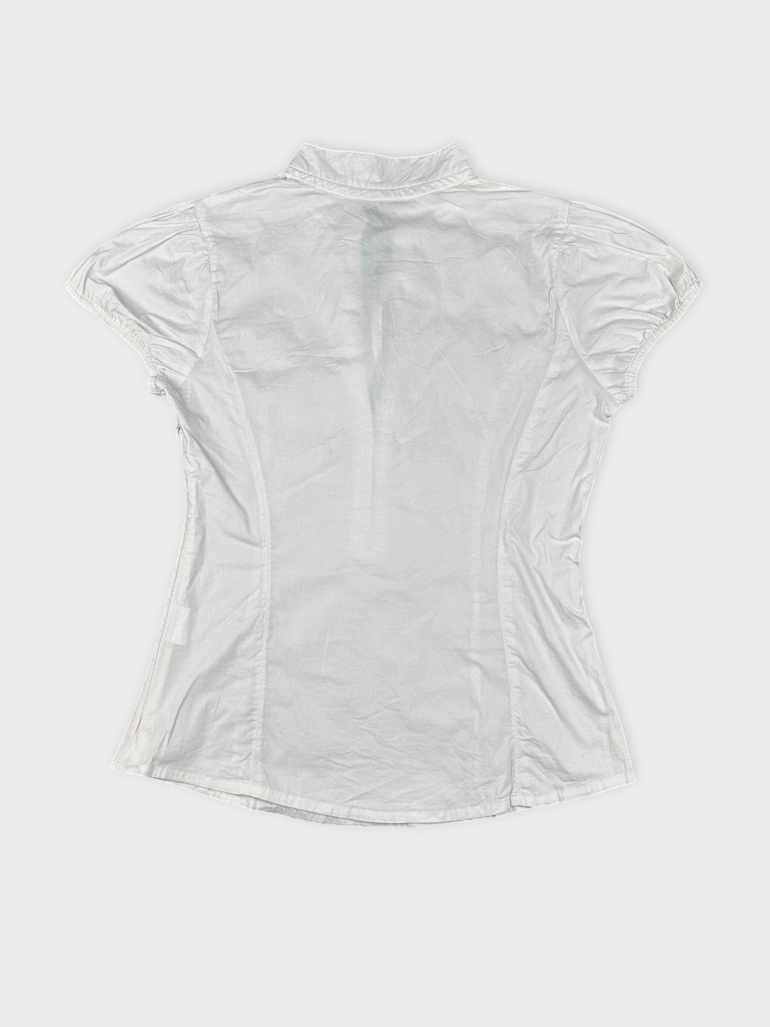 Back view of a white short-sleeve blouse with a collared neckline.