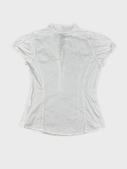 Back view of a white short-sleeve blouse with a collared neckline.