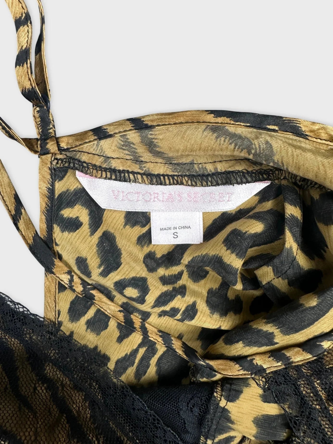 Detail view of a brown silk camisole featuring an animal print and lace trim.