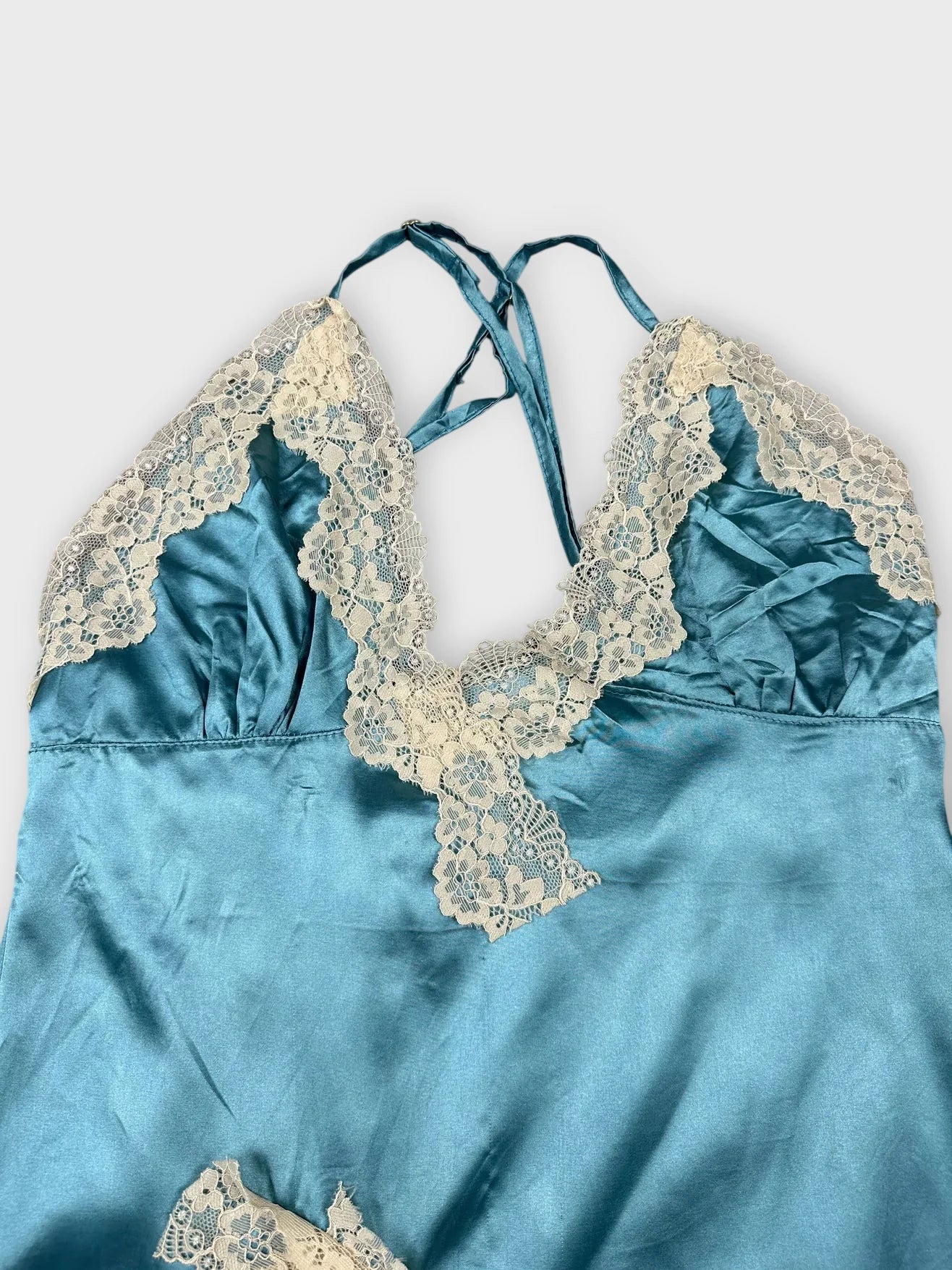 Silk blue camisole with lace trim detail view showing neckline and straps.