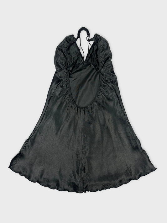 Back view of a silky black halter top with adjustable straps and flowing design.