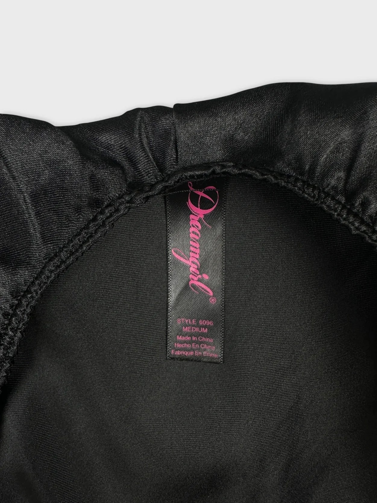 Detail view of a black halter top with adjustable straps and smooth fabric.