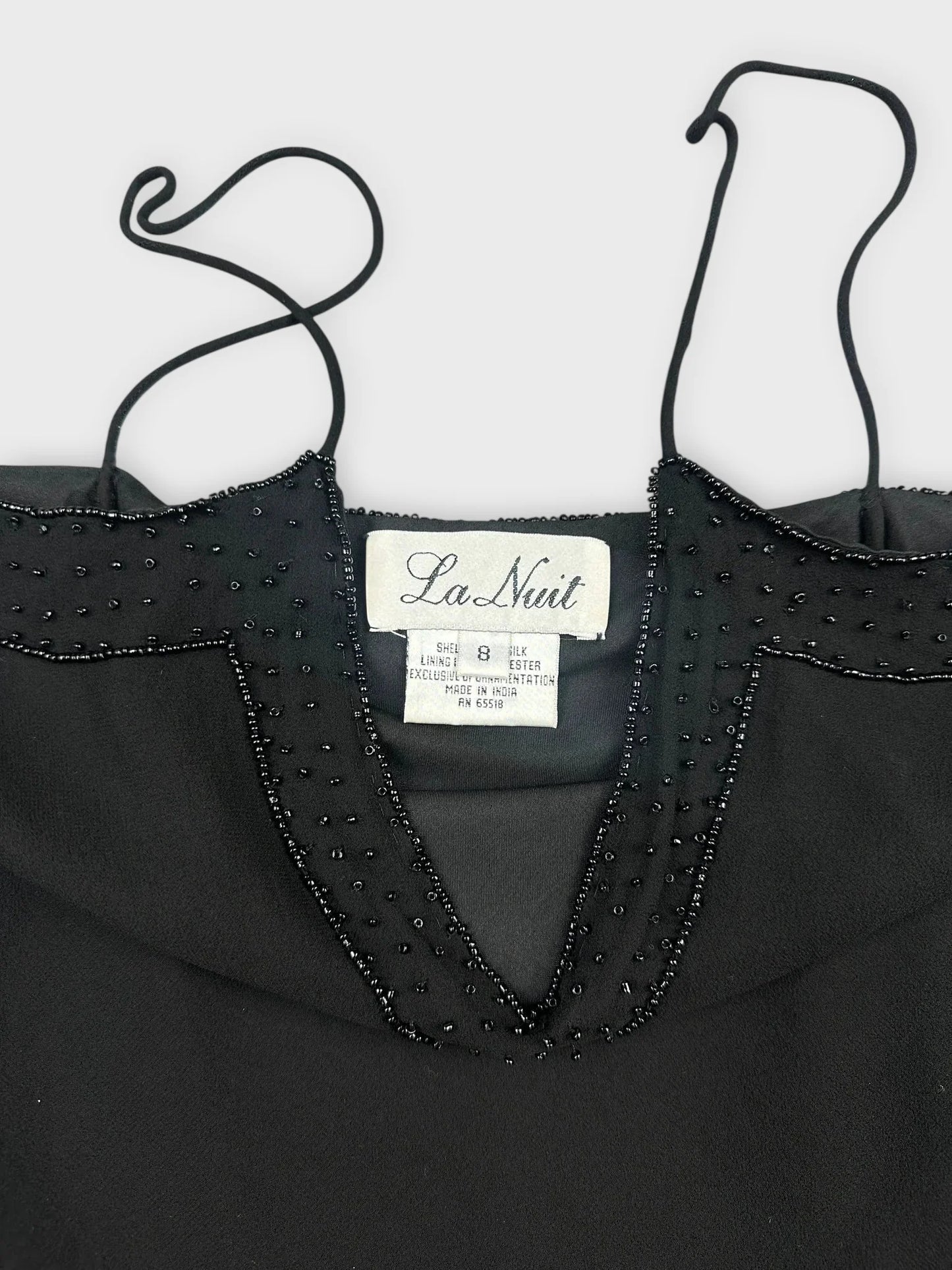 Front view of a black silk camisole featuring lace and bead detailing.