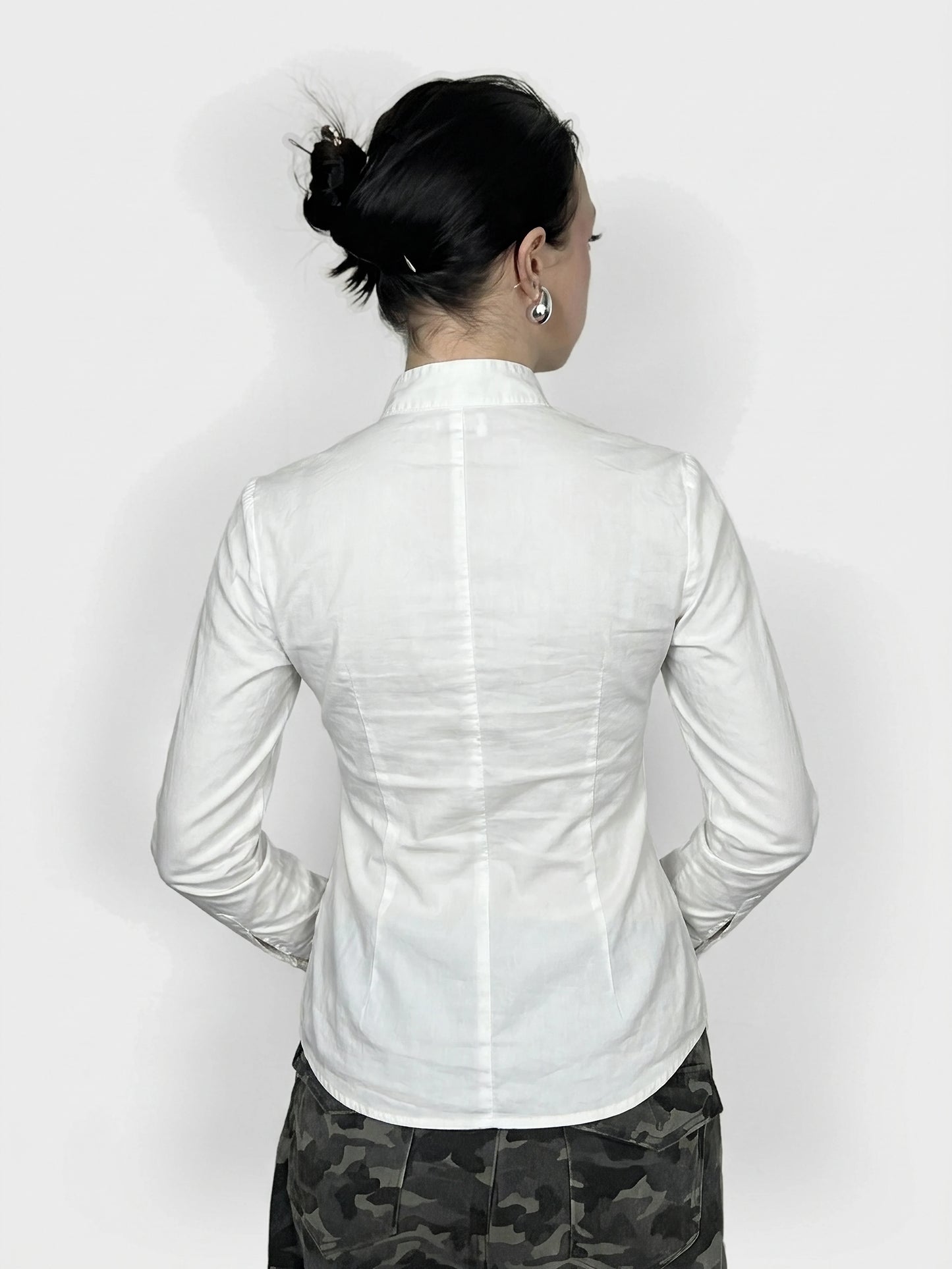 Back view of a sleek white long sleeve button-up with tailored shape.