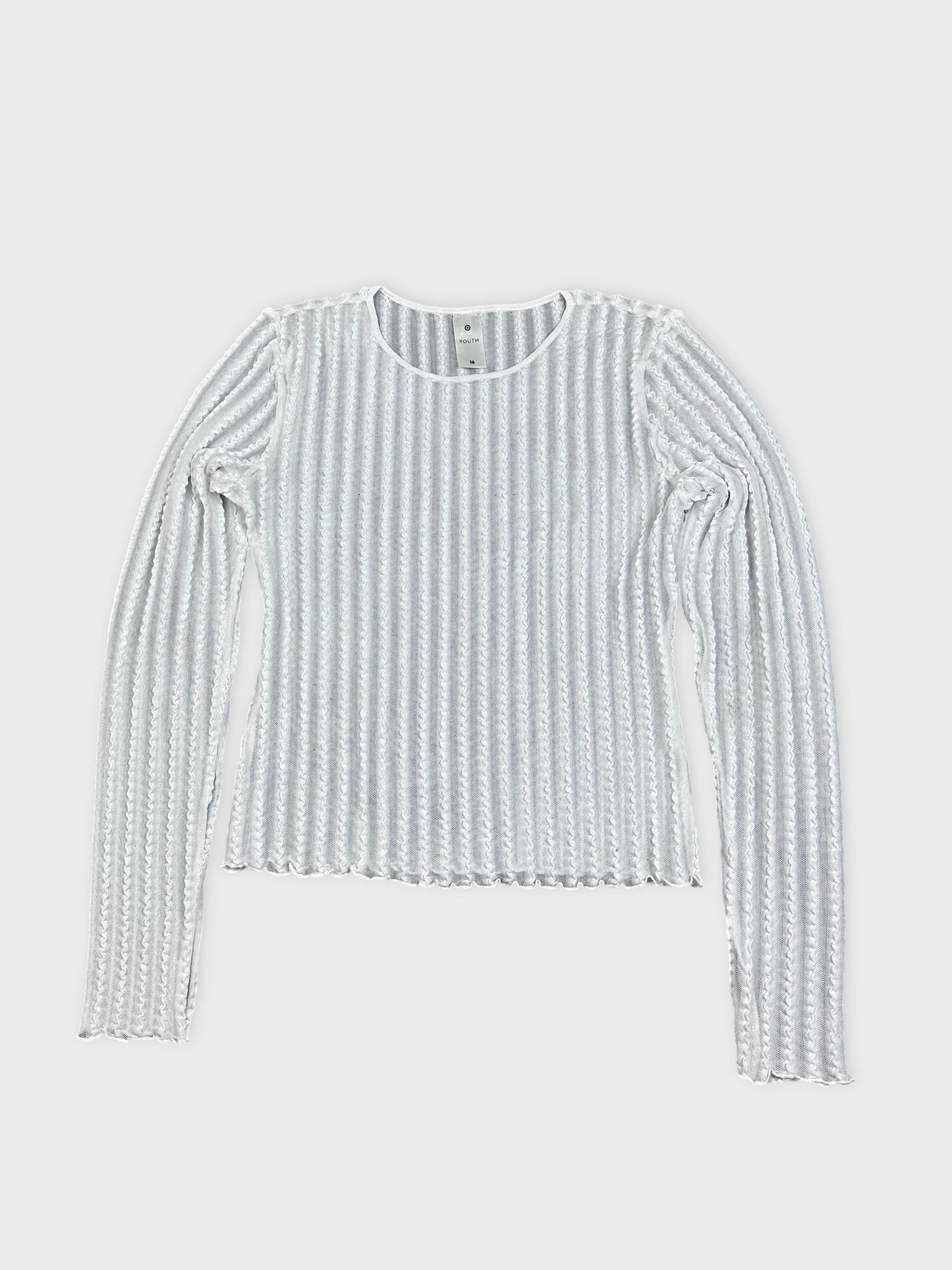 Detail view of a white ribbed knit shirt with long sleeves.
