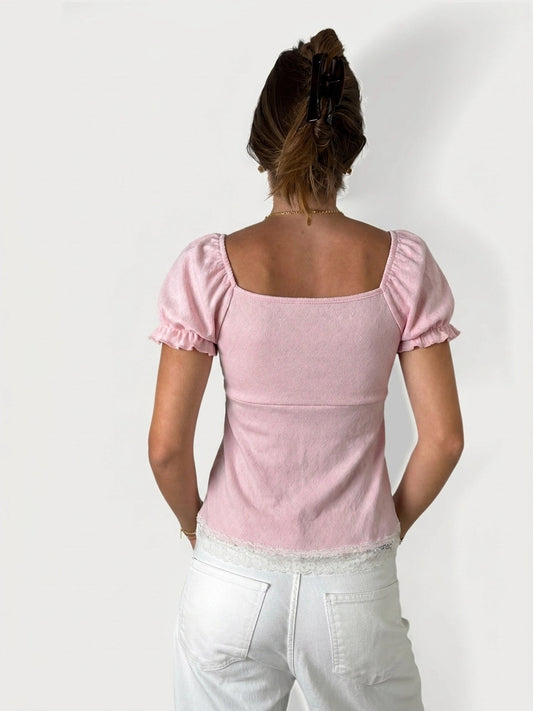 Back view of soft pink lace-trim blouse with short puff sleeves.