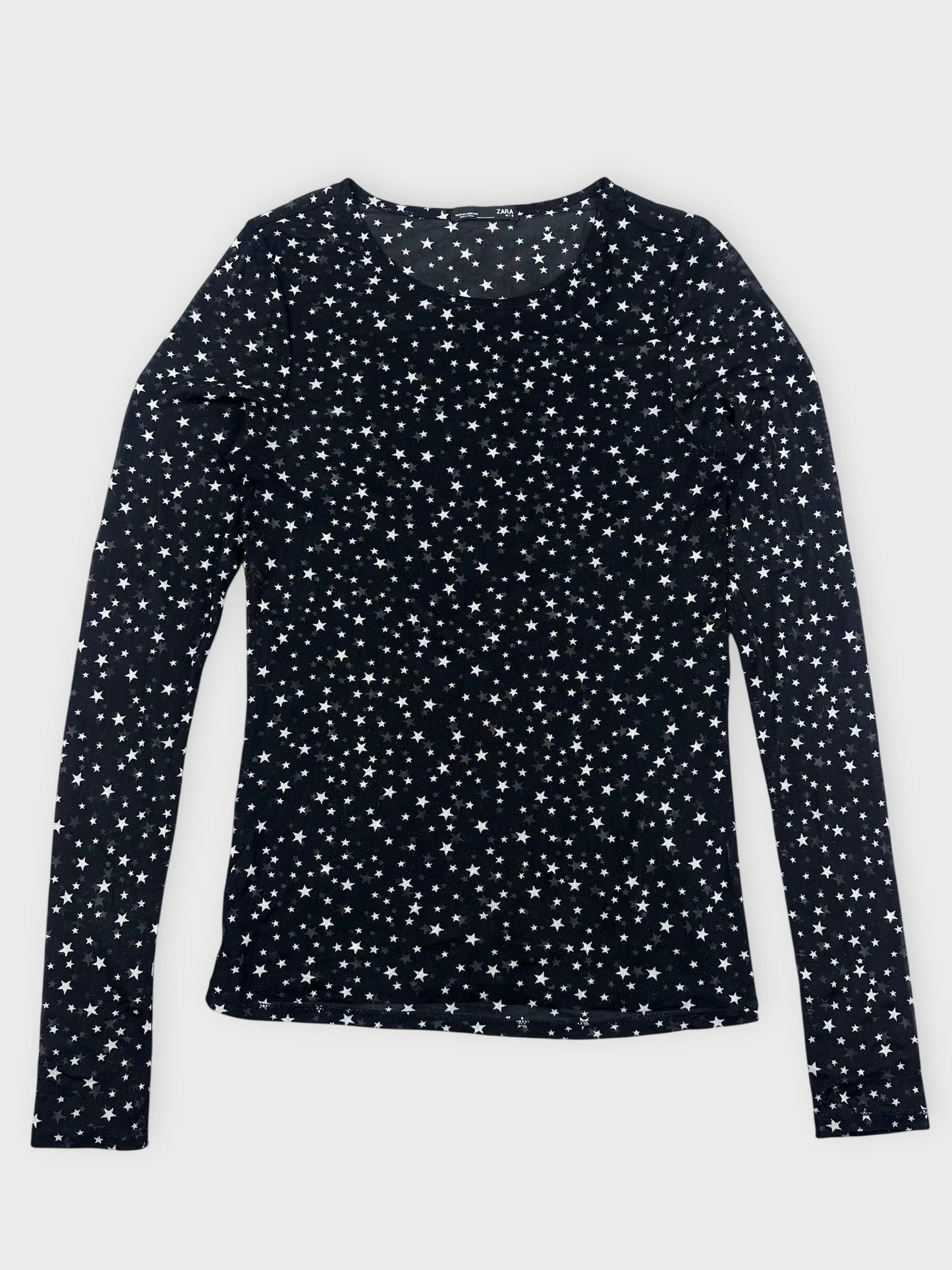 Detail view of a black long sleeve top with a star print.