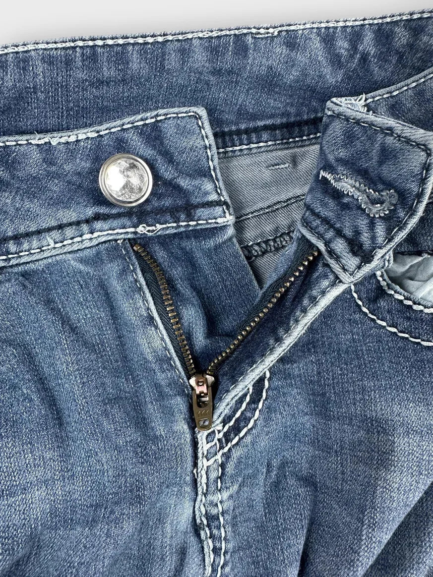 Front view of stylish denim jeans featuring a visible zipper and button detail.