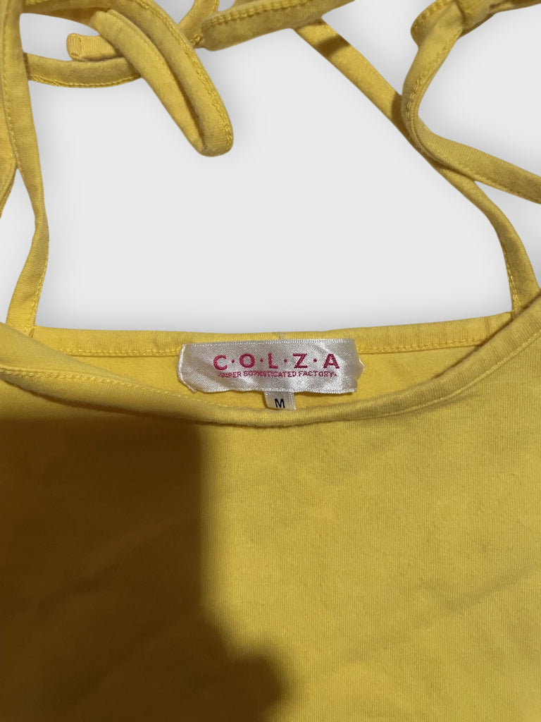 Detail view of a sunshine yellow tank top with tie-shoulder straps.