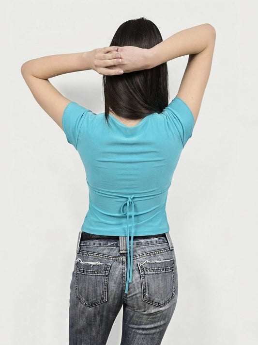Back view of a turquoise short sleeve top with tie detail.