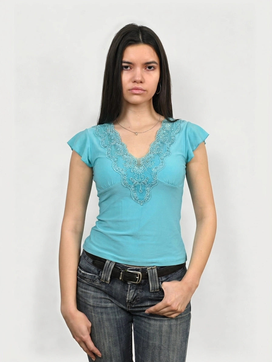 Turquoise short sleeve top with embroidered detail, front view.