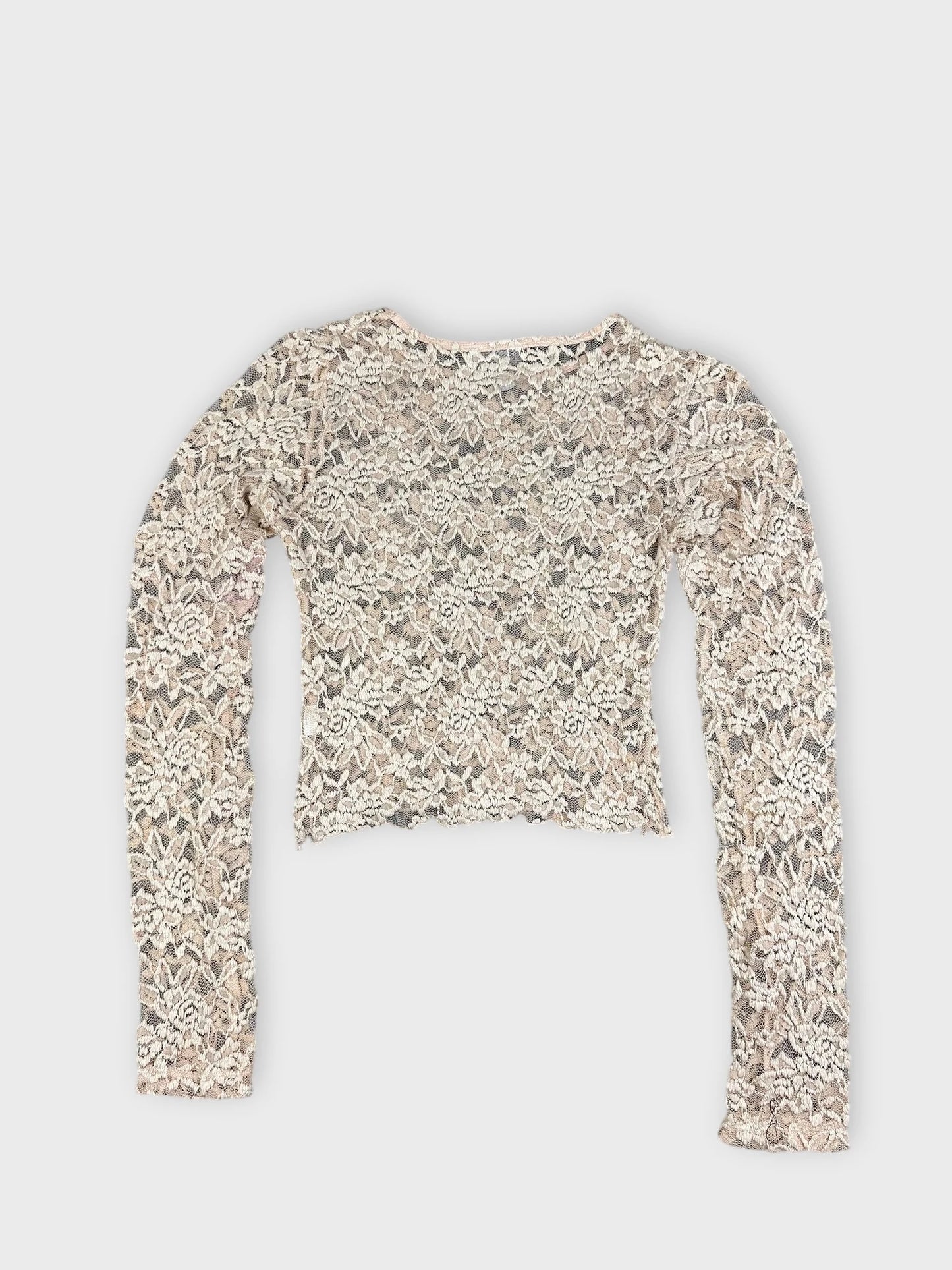 Back view of a vintage cream lace crop top with long sleeves.