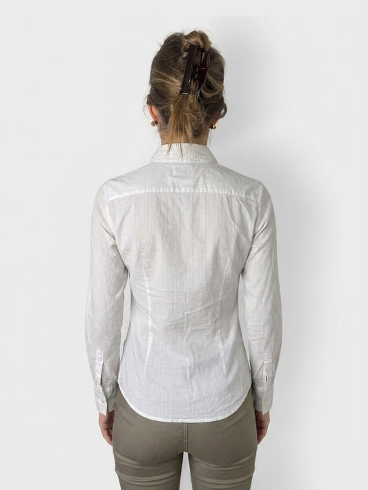 Back view of a white cotton button-up shirt with a collar.