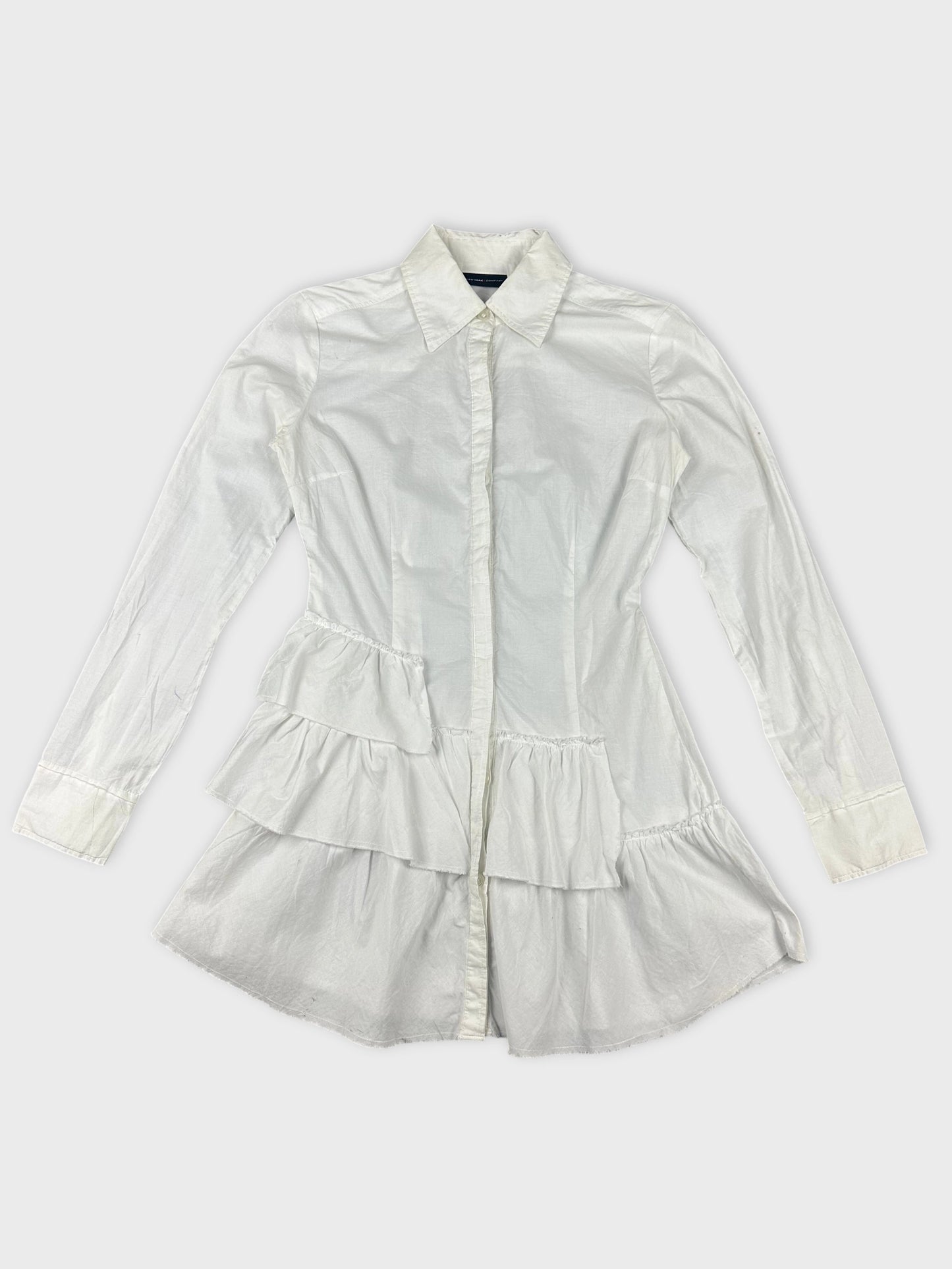 Detail view of white cotton peplum button-up shirt with tiered ruffles.