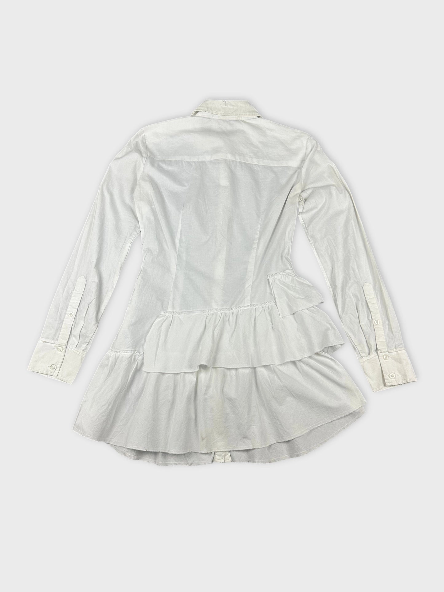 Detail view of a white cotton peplum button-up shirt with layered ruffles.