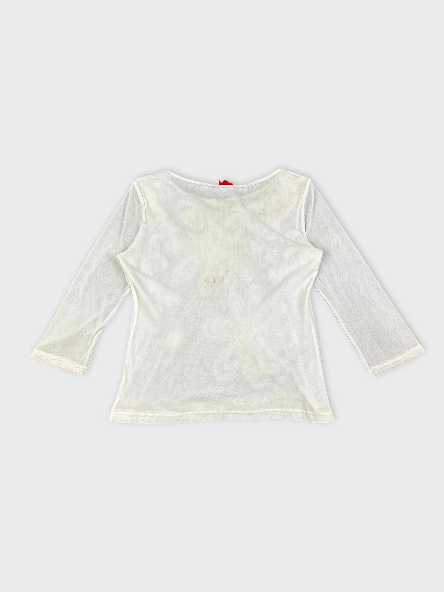 Back view of a white long sleeve top with floral embellishments.