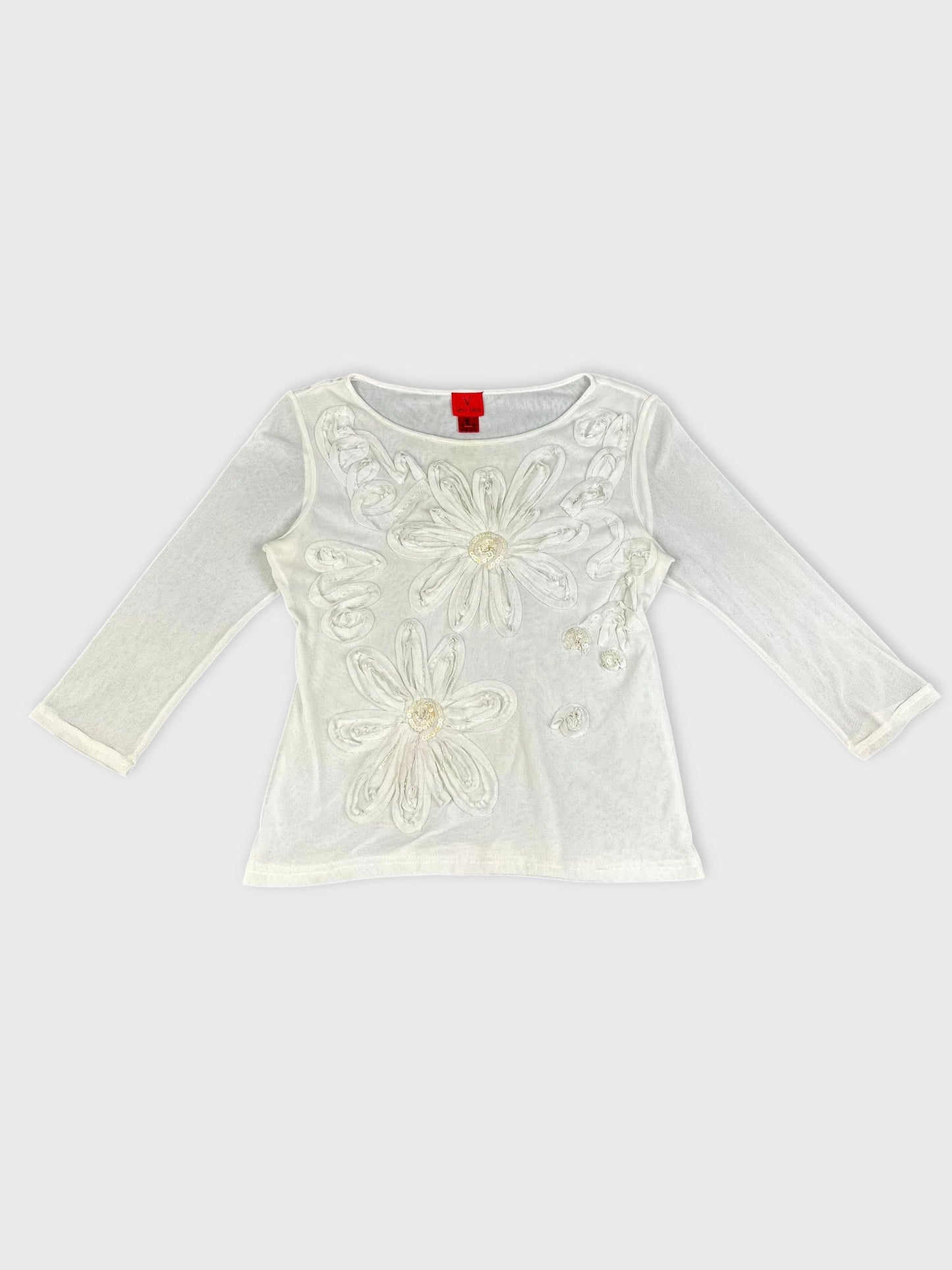 Front view of a white long sleeve top with floral embellishments.