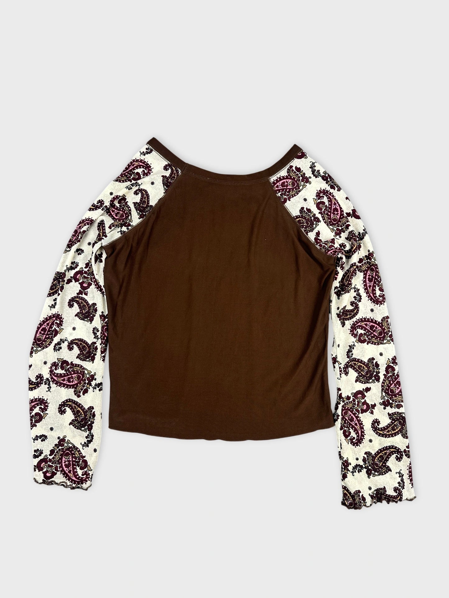 Back view of a brown body shirt with paisley print sleeves.