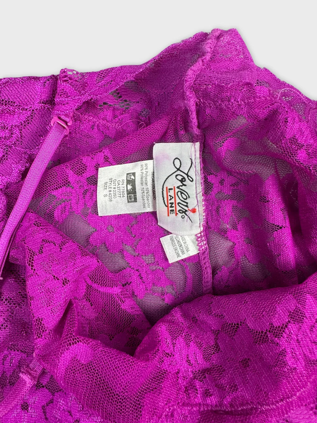 Detail view of a pink lace women body shirt showing floral pattern.