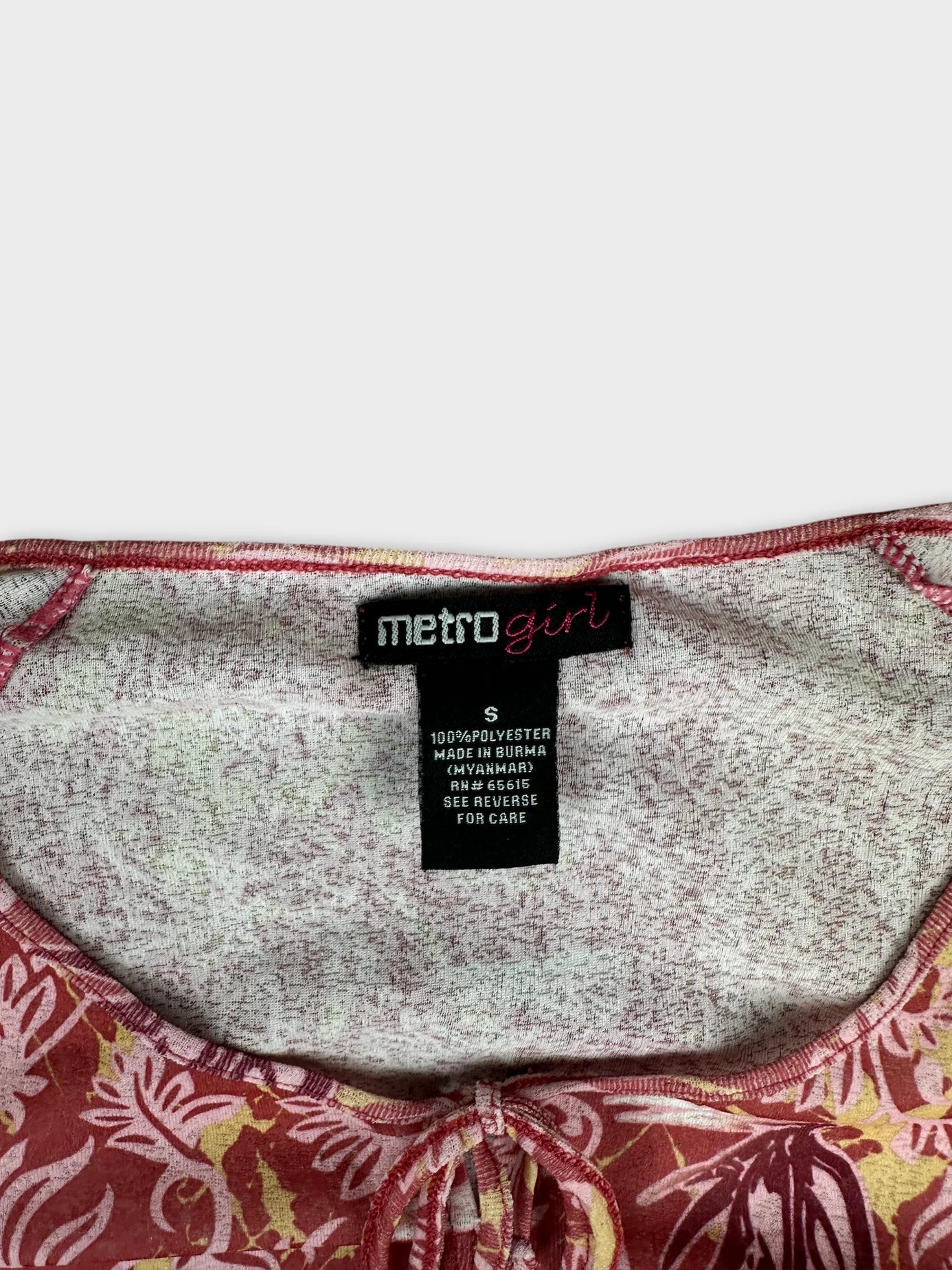 Detail view of a vintage women body shirt in pink with floral print.