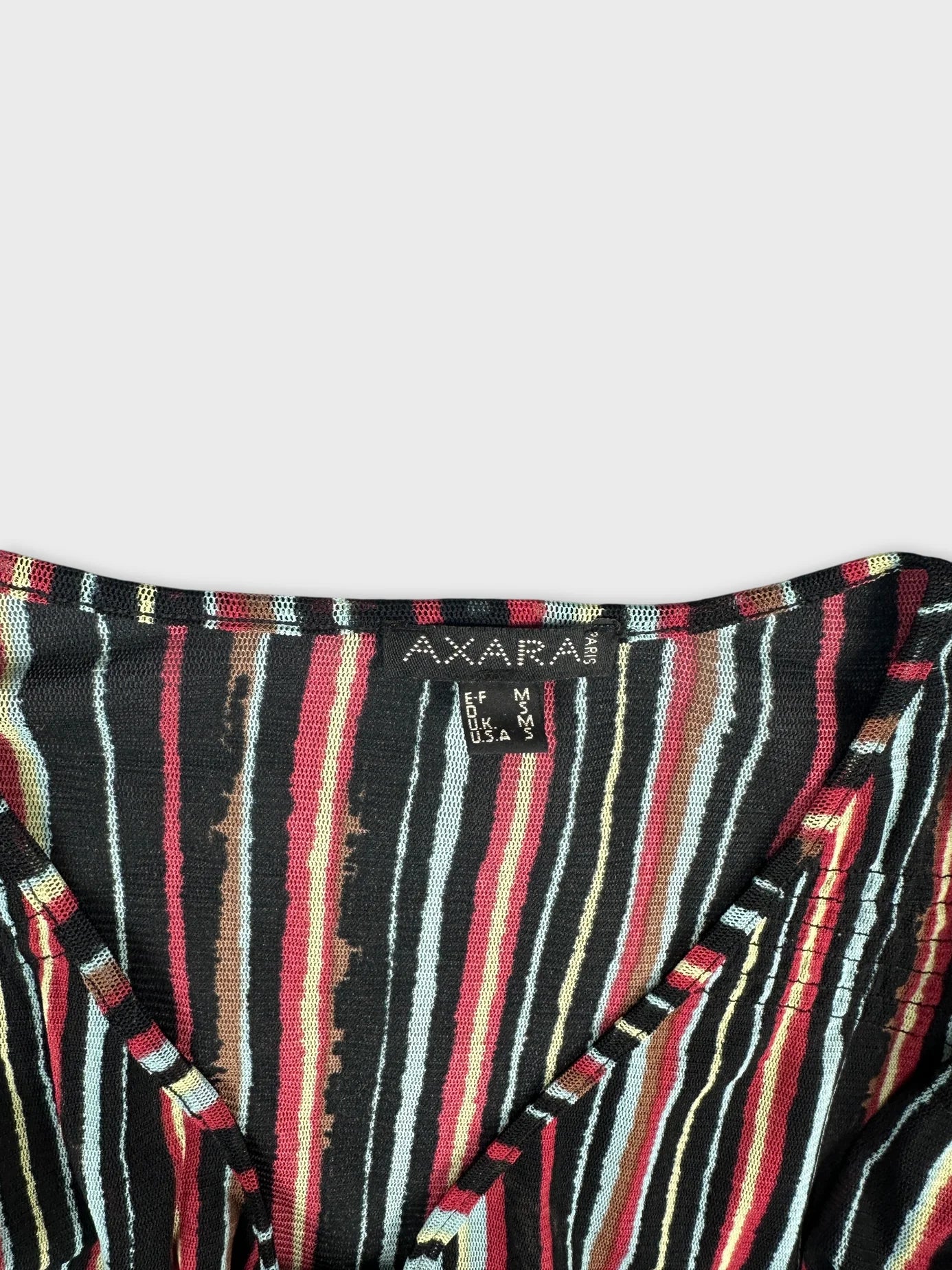 detail view of a black women body shirt with colorful striped pattern