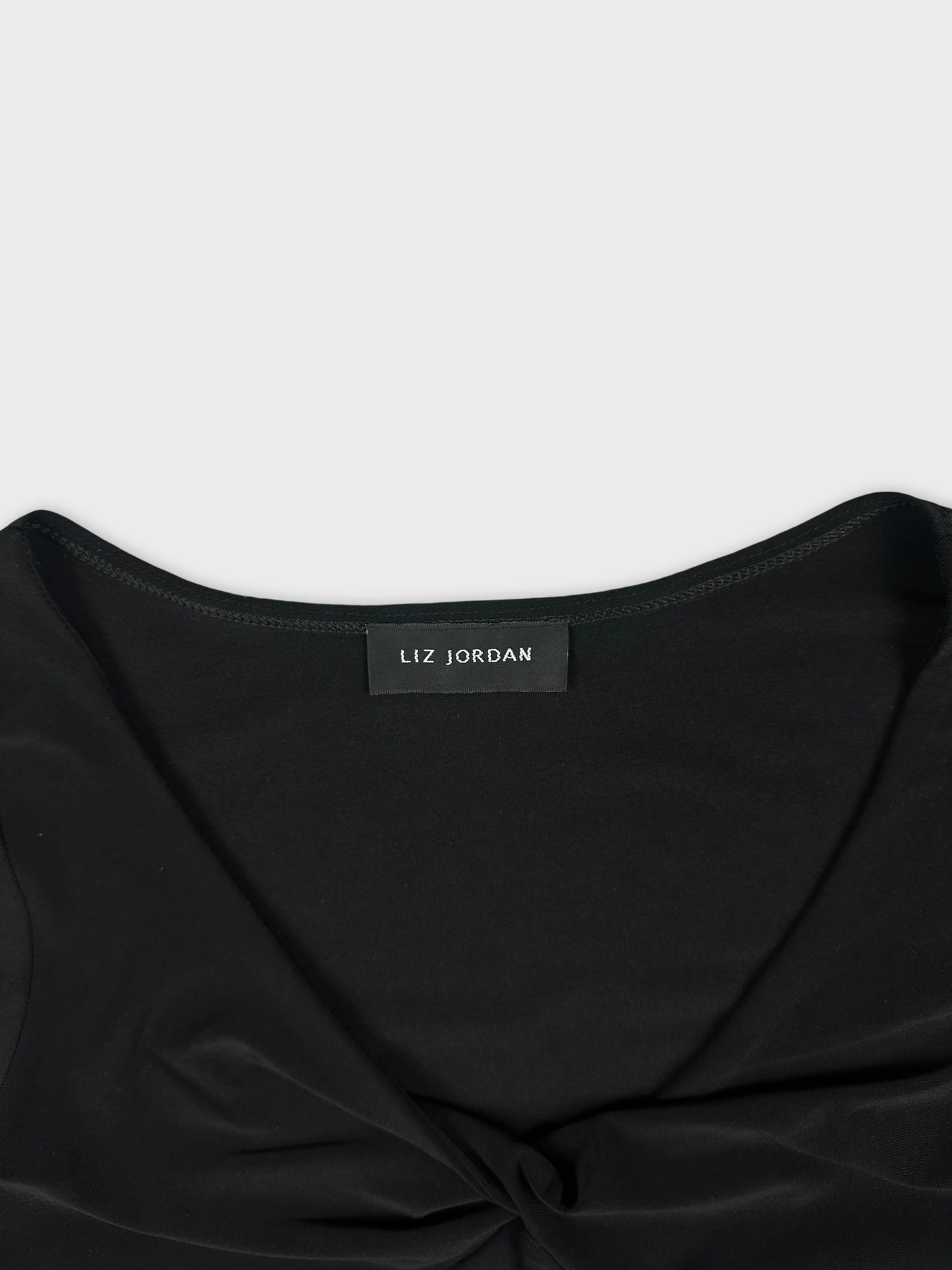 Black body shirt detail view featuring a twisted front design.