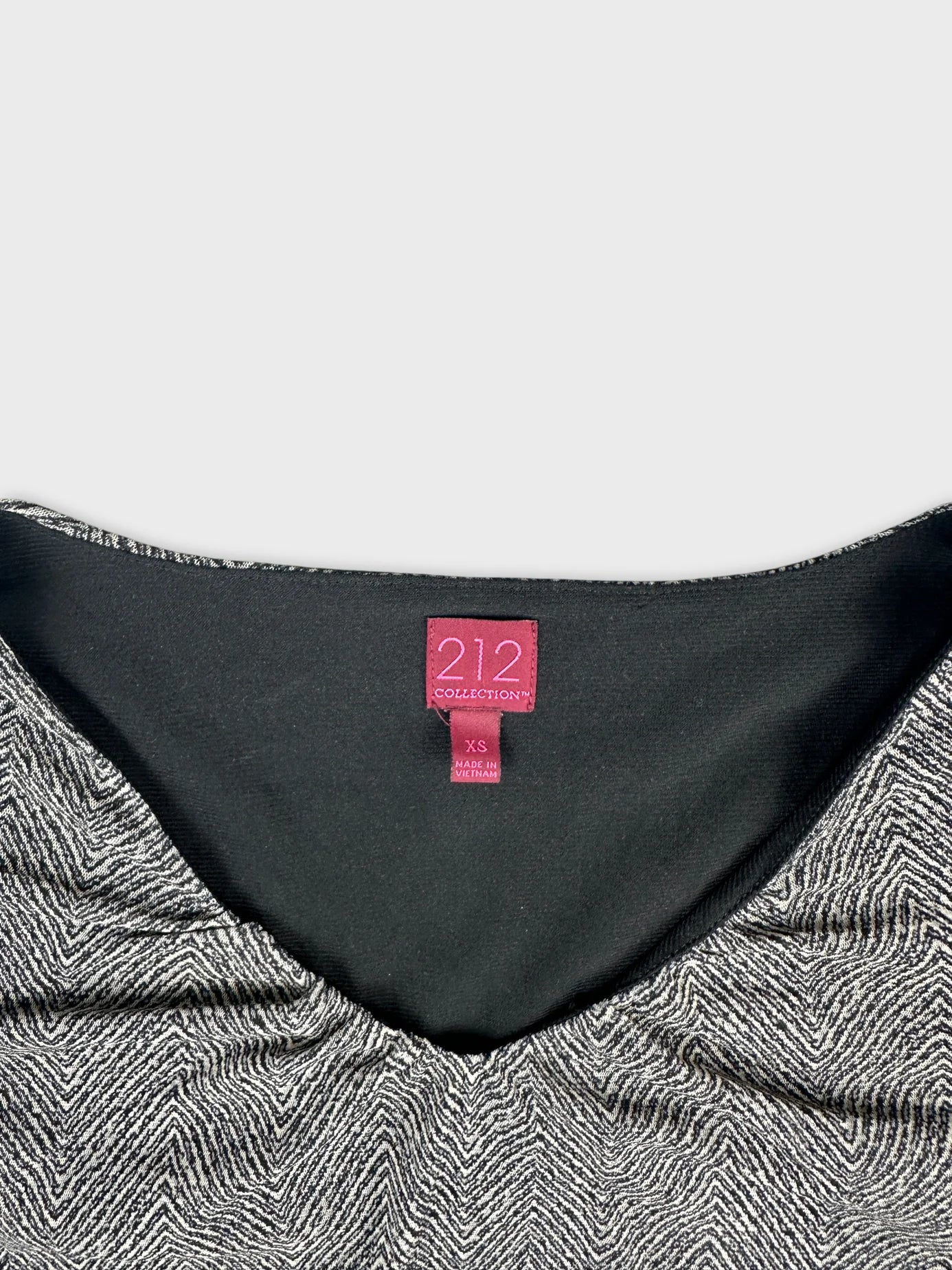 Detail view of a black and white patterned body shirt with a v-neck design.
