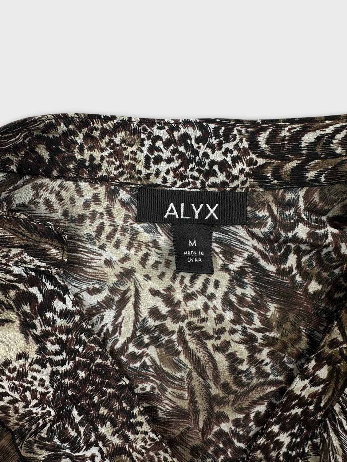 Detail view of a women's body shirt in brown and cream animal print.