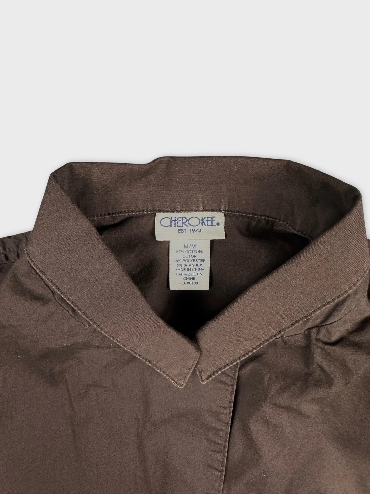 Detail view of brown women body shirt featuring a classic collar.