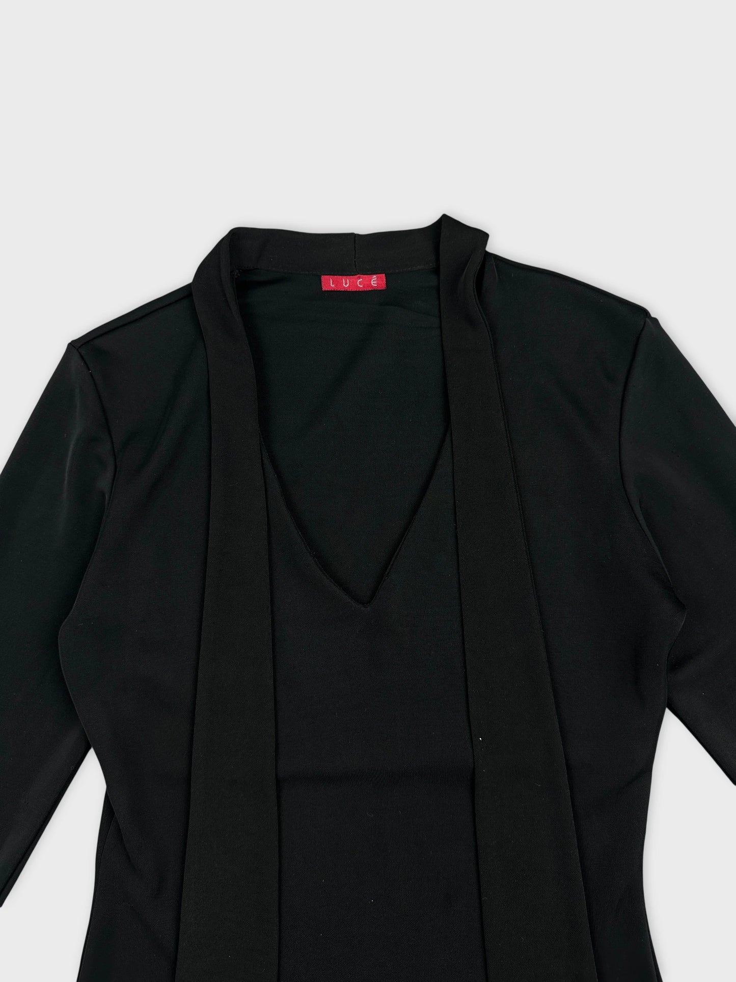 Detail view of a black women body shirt featuring a v-neckline.
