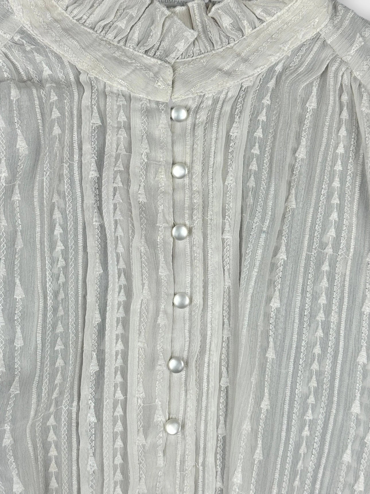 detail view, Women body shirt in light gray detailed view with textured stripes and pearl buttons.