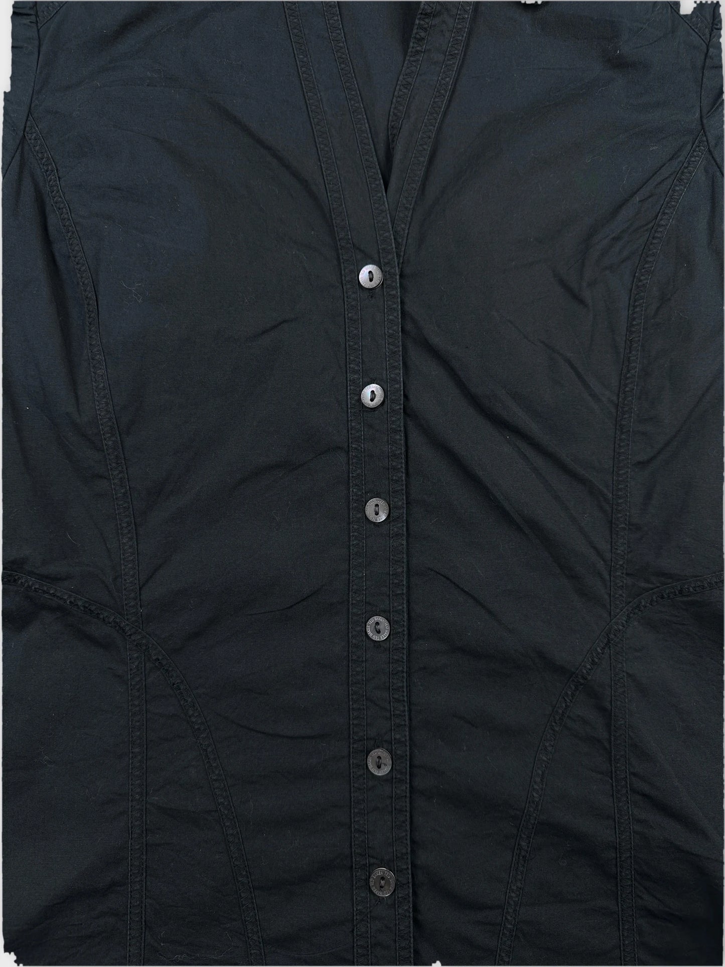 Detail view of a black body shirt featuring a button placket and fitted shape.