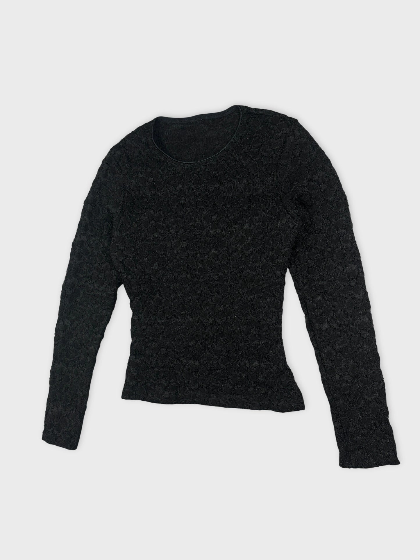 Detail view of black women's body shirt featuring textured floral pattern.
