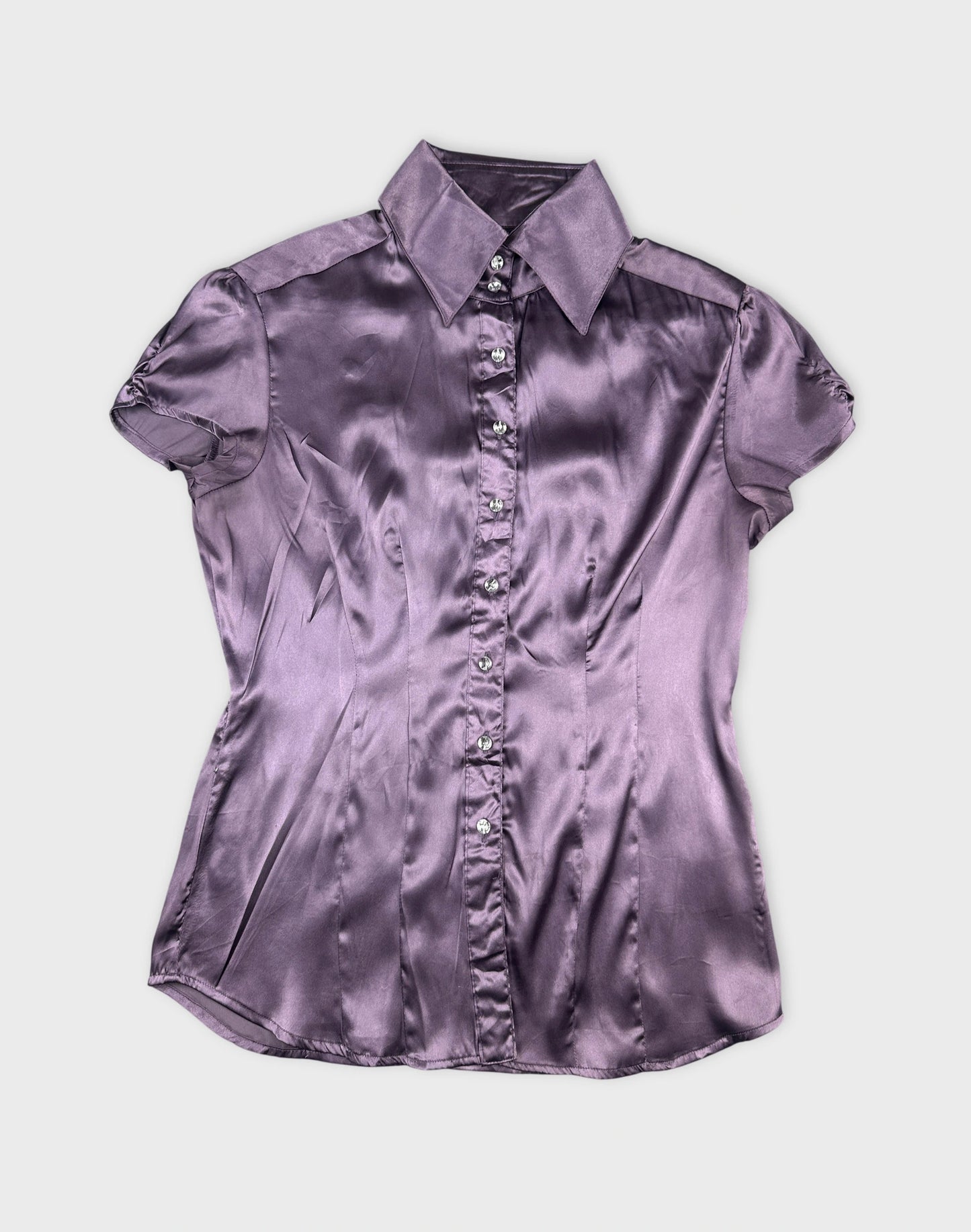 Front view of a purple women body shirt with shiny fabric and button detail.
