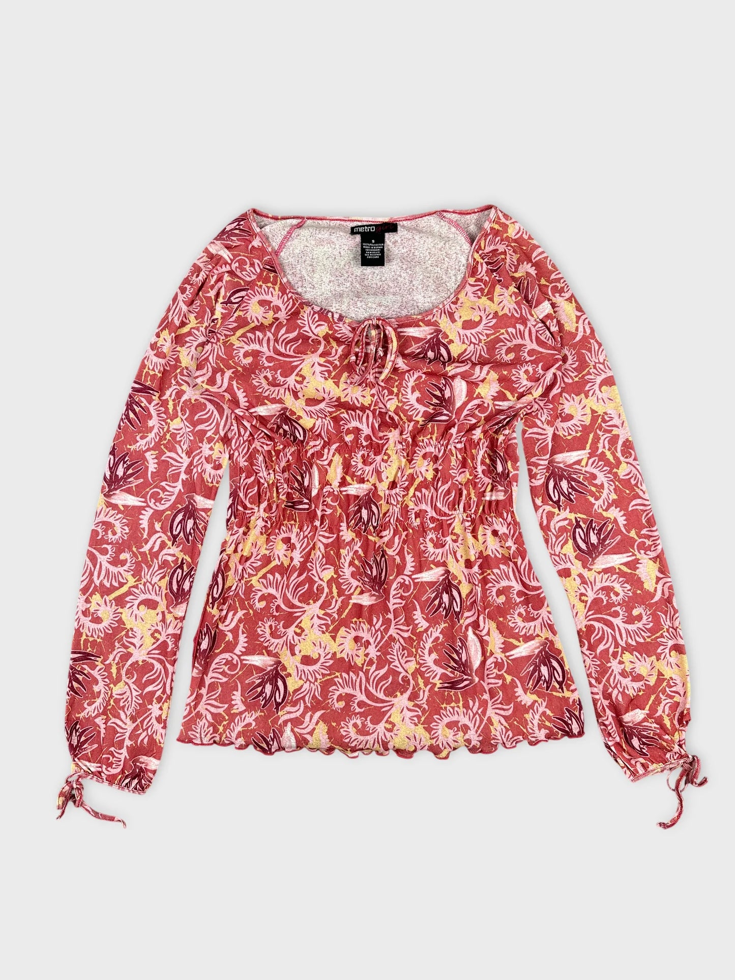 Front view of a pink floral body shirt with drawstring detail.