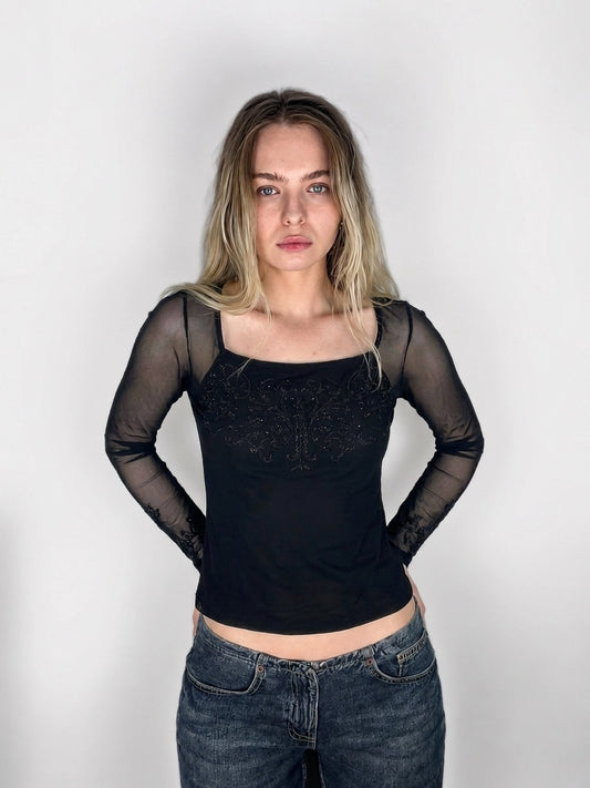 Black long-sleeve body shirt with intricate embellishments, front view.