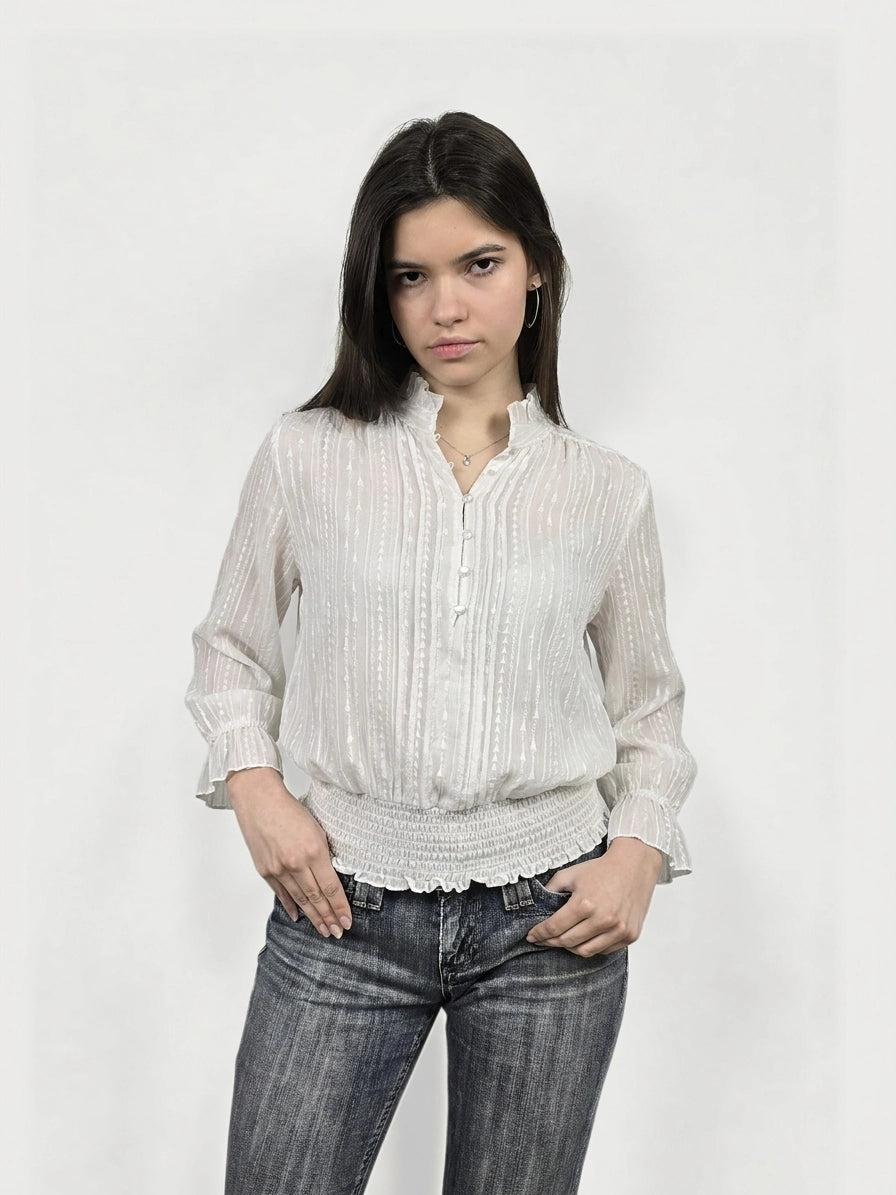 Front view of a white body shirt featuring a ruffled neckline and shirred hem.