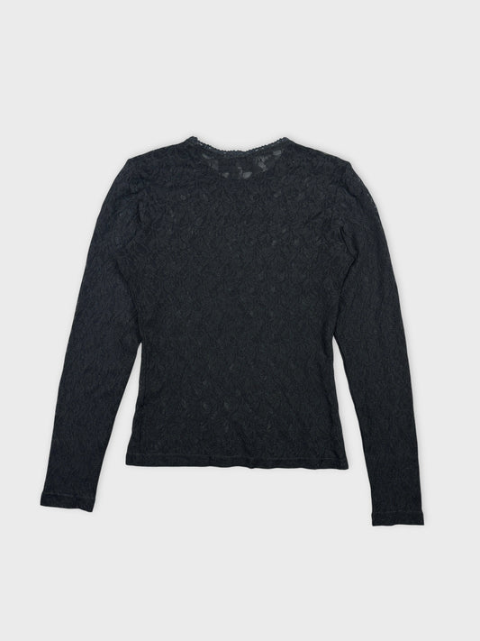 Back view of a black long-sleeve lace body shirt with floral pattern.