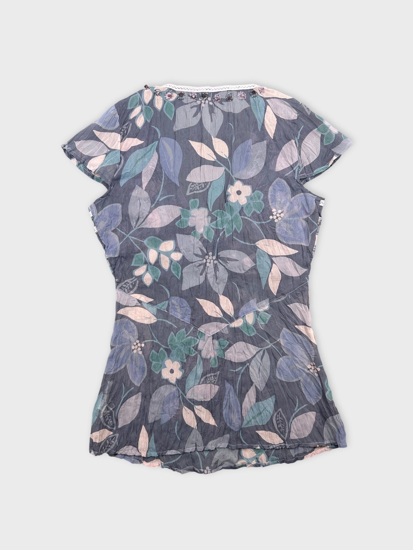 Back view of a women’s body shirt in blue with floral print.