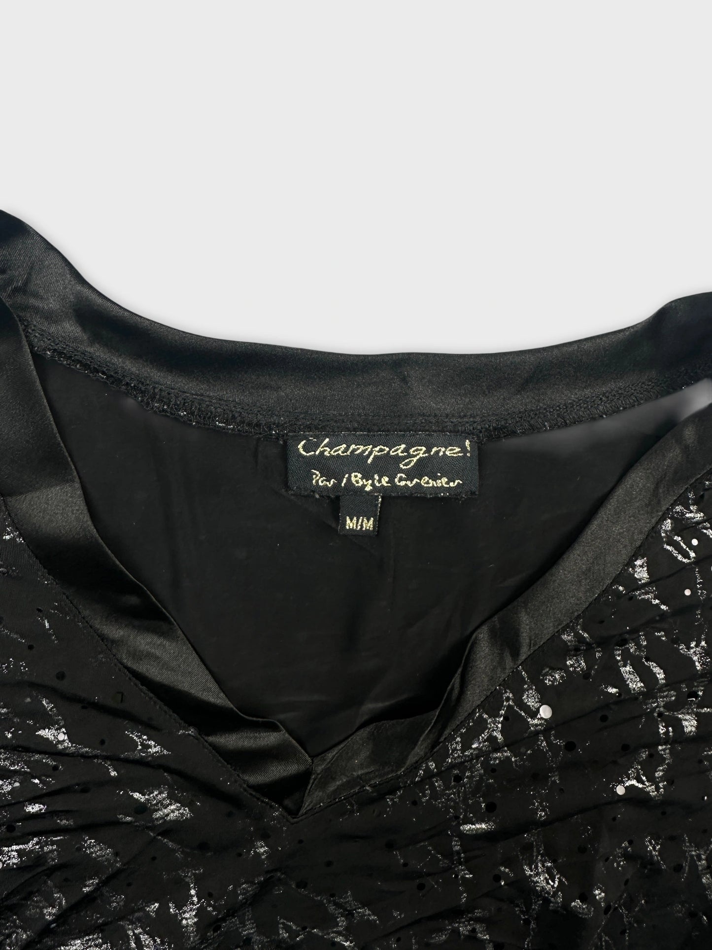 Detail view of a black body shirt featuring a satin neckline and intricate patterns.
